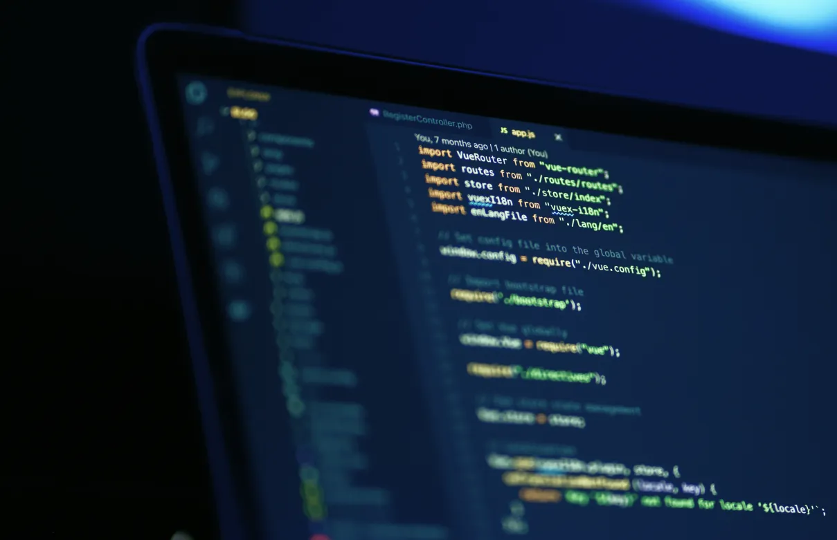 Manos de una persona sobre el teclado de un portátil, escribiendo código.